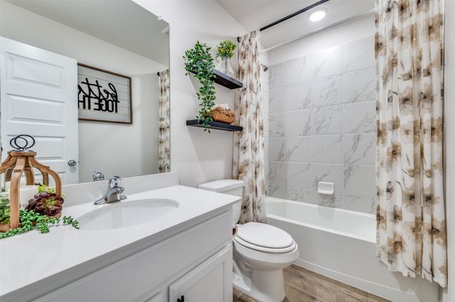 Bathroom featuring toilet, shower / bath combo with shower curtain, vanity, and wood finished floors | Image 19