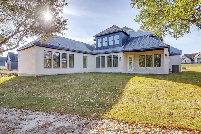Back of property featuring central air condition unit, brick siding, a lawn, and roof with shingles | Image 33