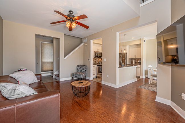 Living room with ceiling fan and dark wood-style flooring | Image 7