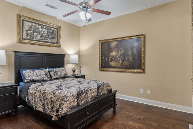 Bedroom with baseboards, wood finished floors, ornamental molding, and ceiling fan | Image 15
