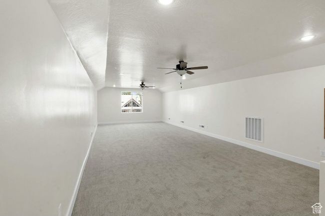 Bonus room with carpet, vaulted ceiling, visible vents, baseboards, and ceiling fan | Image 29