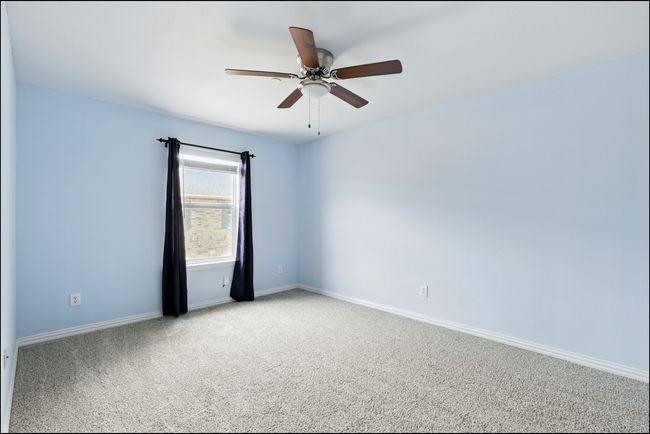 Empty room with a ceiling fan, baseboards, and carpet | Image 28