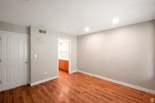 Unfurnished bedroom with light wood-style floors, connected bathroom, and recessed lighting | Image 10