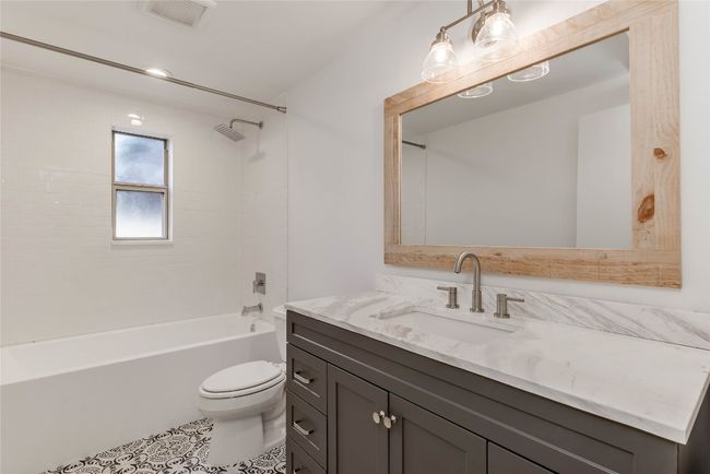Full bath featuring toilet, vanity, tile patterned floors, and bathtub / shower combination | Image 20
