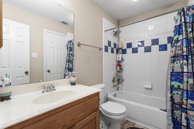 Bathroom featuring shower / bathtub combination with curtain, vanity, and toilet | Image 32