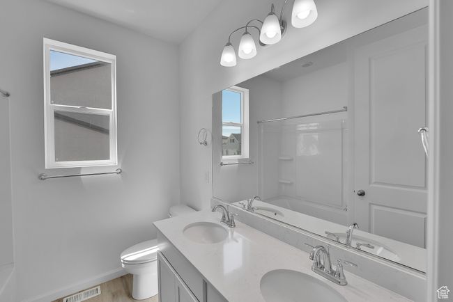 Full bathroom featuring double vanity, washtub / shower combination, and wood finished floors | Image 20