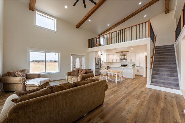 Living room featuring light wood finished floors, plenty of natural light, stairs, and beamed ceiling | Image 8