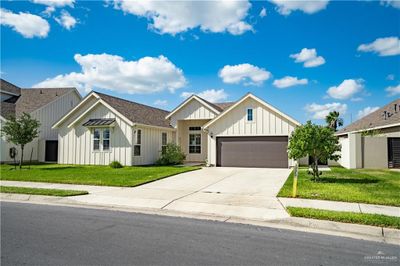 Modern farmhouse style home with a garage and a front lawn | Image 1