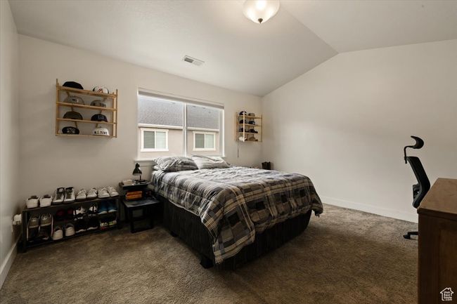 Carpeted bedroom featuring lofted ceiling, visible vents, and baseboards | Image 11