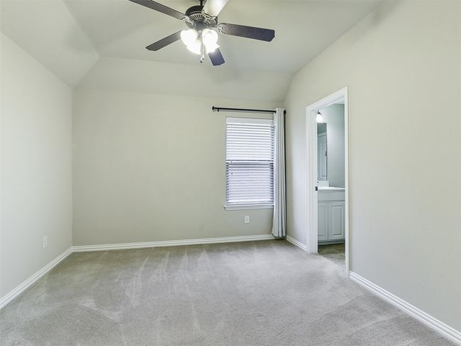 Unfurnished bedroom featuring carpet, vaulted ceiling, connected bathroom, and ceiling fan | Image 28