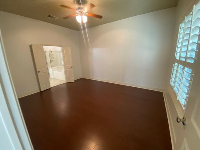 Primary bedroom has large picture window with views of backyard. | Image 21