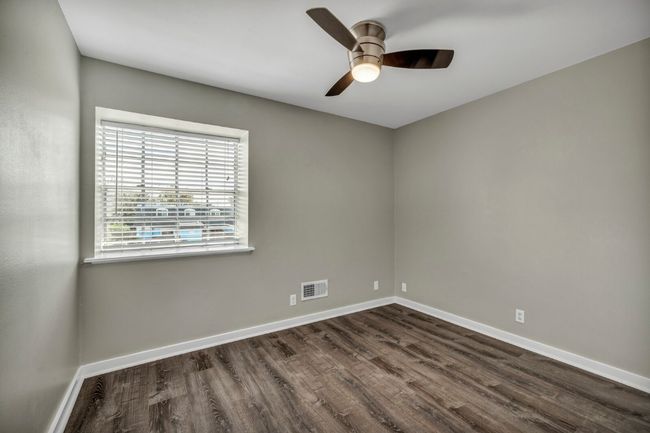 Unfurnished room with dark wood-style floors, ceiling fan, and baseboards | Image 14