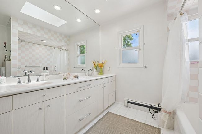 Bathroom with healthy amount of natural light, a skylight, tile patterned floors, double vanity, and recessed lighting | Image 20