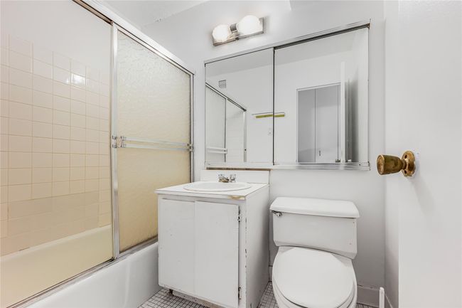 Bathroom with visible vents, tile patterned floors, toilet, enclosed tub / shower combo, and vanity | Image 8