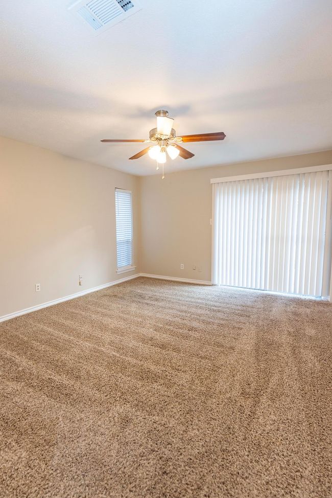 Carpeted empty room with a ceiling fan and baseboards | Image 14