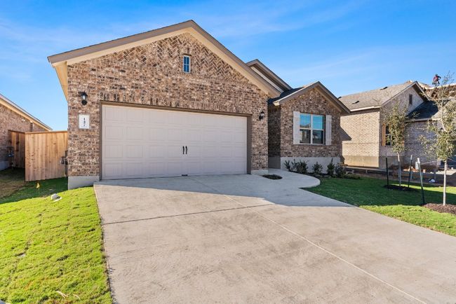 View of front of house with concrete driveway, brick siding, a garage, and a front lawn | Image 30