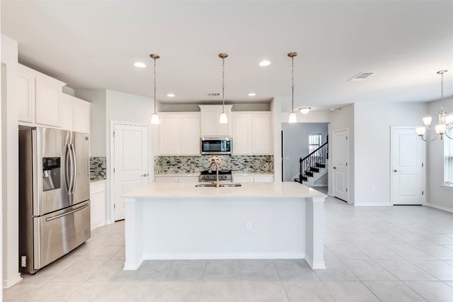 Kitchen with stainless steel appliances, a sink, backsplash, light countertops, and recessed lighting | Image 10