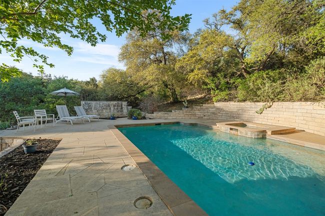 View of swimming pool featuring a patio and a pool with connected hot tub | Image 34