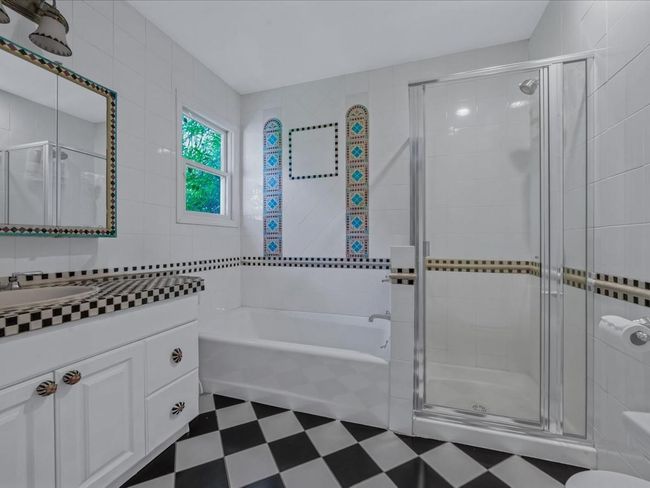 Full bathroom with tile patterned floors, vanity, a garden tub, a stall shower, and tile walls | Image 26