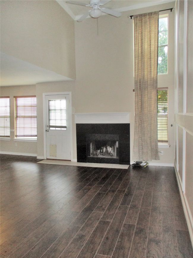 Unfurnished living room featuring ceiling fan and dark hardwood / wood-style flooring | Image 4