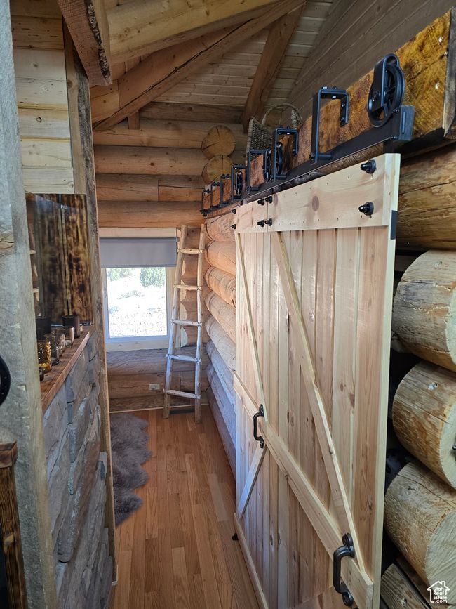 Interior space with log walls, vaulted ceiling with beams, wood finished floors, and wooden ceiling | Image 118