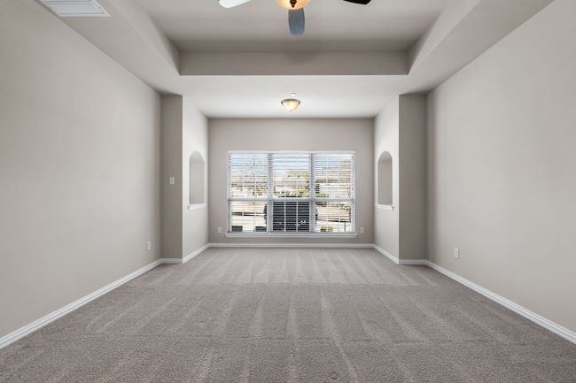 Tray ceilings and wall of windows look out to green belt. | Image 10