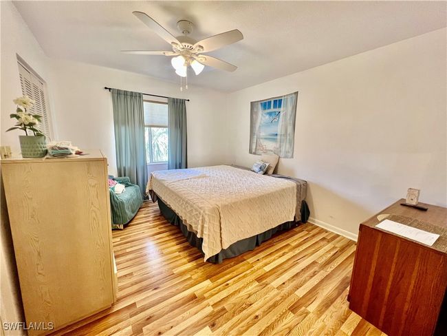 Primary bedroom with ceiling fan, light wood finished floors and private ensuite bathroom. | Image 13