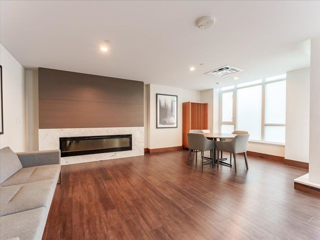 Partyroom featuring a high end fireplace, wood finished floors, baseboards, and recessed lighting | Image 31