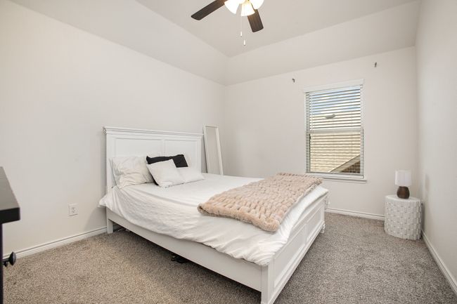 Bedroom featuring carpet flooring, baseboards, vaulted ceiling, and a ceiling fan | Image 23