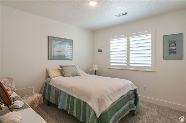 Bedroom featuring carpet flooring, a textured ceiling, and baseboards | Image 23