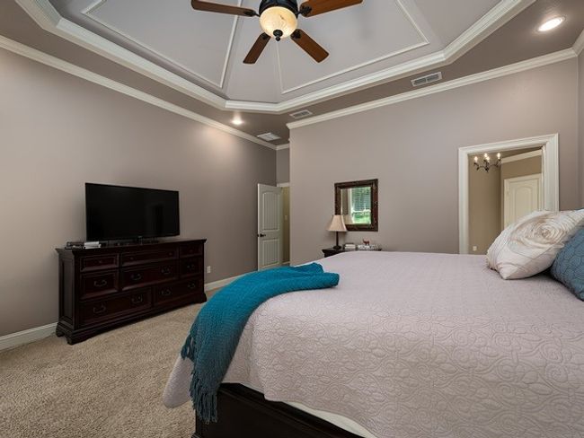 Carpeted bedroom with ceiling fan with notable chandelier, visible vents, recessed lighting, and ornamental molding | Image 18