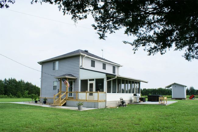 View of front of home with a sunroom, a front lawn, and a patio | Image 7