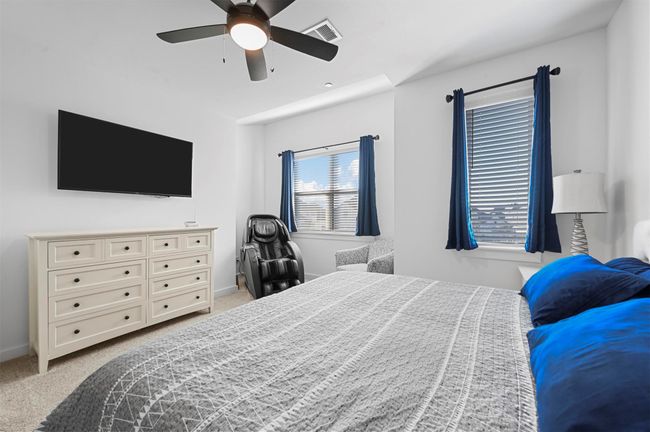 Bedroom with light colored carpet and ceiling fan | Image 18