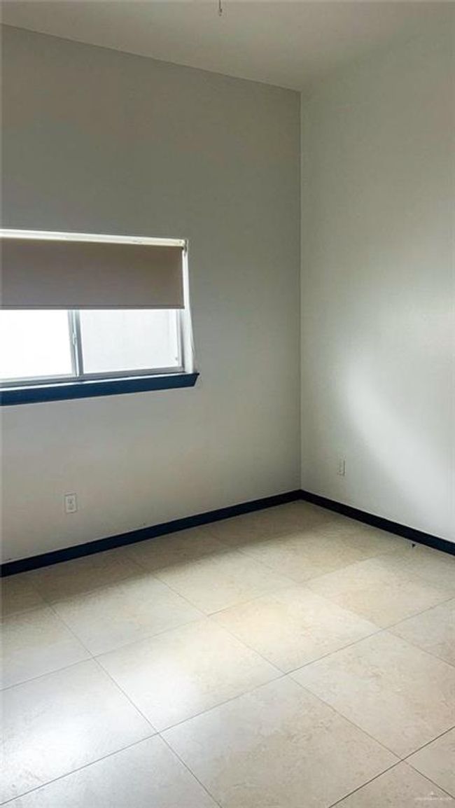 Spacious second bedroom with plenty of natural light and tile flooring. | Image 10