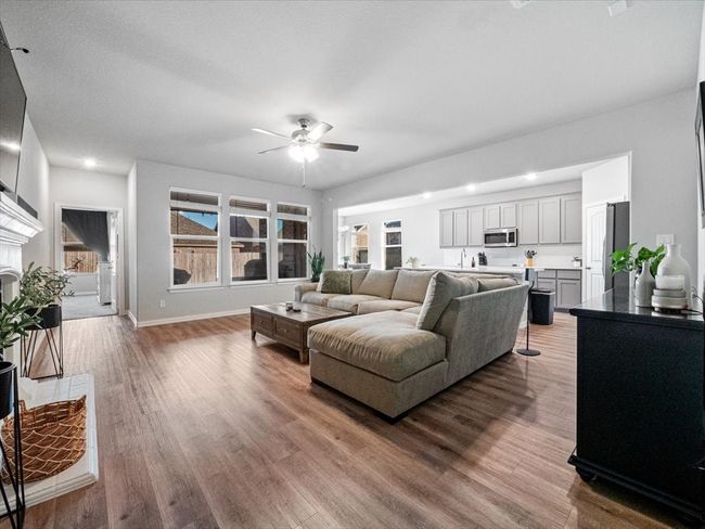 Living room with ceiling fan, light wood finished floors, baseboards, and recessed lighting | Image 10