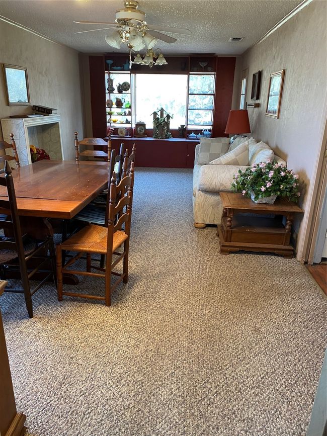 Carpeted dining space featuring ceiling fan and a textured ceiling | Image 16