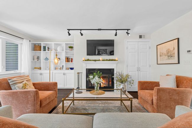 Fireplace flanked with built-ins, track lighting and engineered hardwood flooring | Image 6