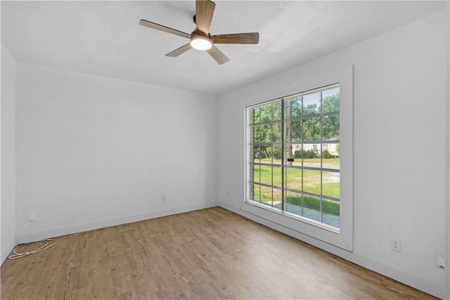 Spare room featuring a ceiling fan, baseboards, and wood finished floors | Image 5