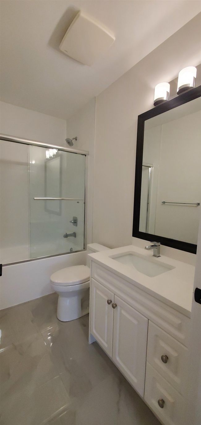 Bathroom featuring vanity, toilet, shower / bath combination with glass door, and marble finish floor | Image 35