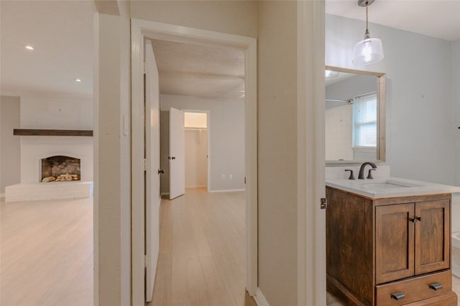 Bathroom featuring wood finished floors, vanity, a fireplace, and a shower | Image 24
