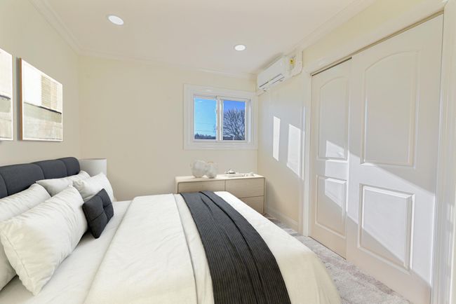 Bedroom with ornamental molding and an AC wall unit | Image 32