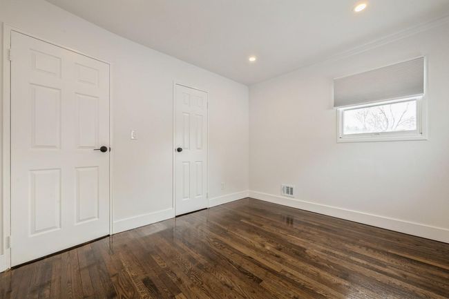 Unfurnished bedroom featuring dark wood-style flooring, baseboards, visible vents, and recessed lighting | Image 10