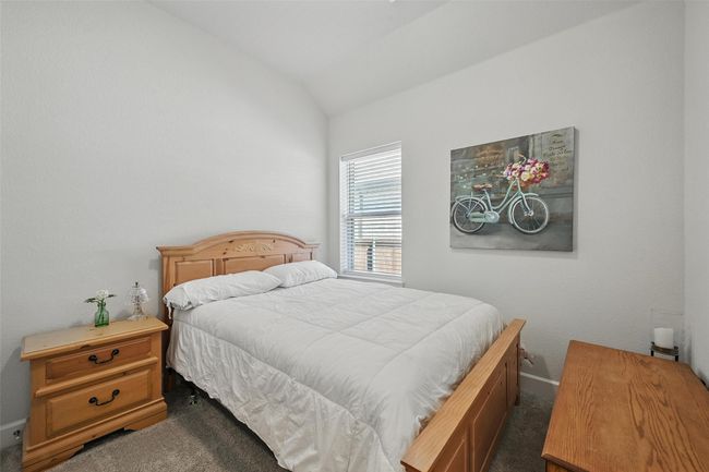 Bedroom featuring dark carpet, lofted ceiling, and baseboards | Image 16