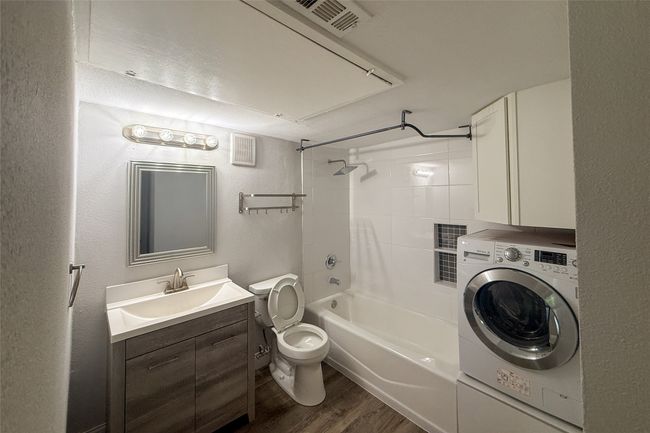 Full bath with washer / dryer, finished floors, vanity, and bathing tub / shower combination | Image 5