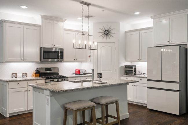 Kitchen with appliances with stainless steel finishes, decorative backsplash, dark wood-style floors, a sink, and pendant lighting | Image 8