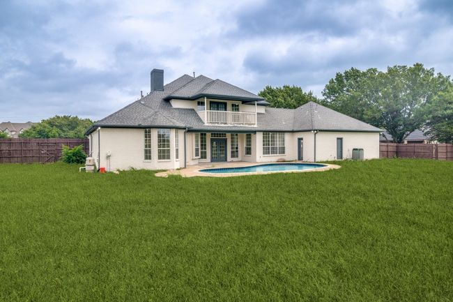 Rear view of house with a balcony, a chimney, and a patio | Image 25