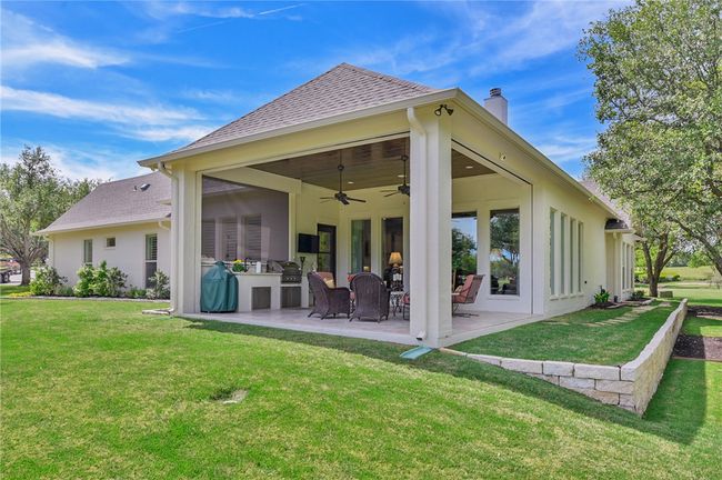 Rear view of property with a chimney, a ceiling fan, a yard, and a patio | Image 23