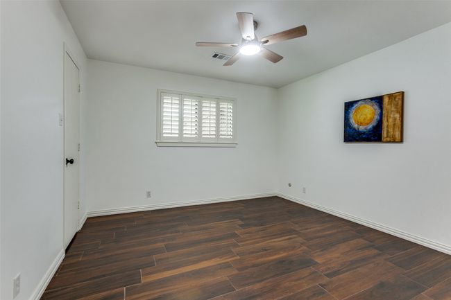 Middle bedroom has a walk-in closet and wood-look tile flooring. | Image 17