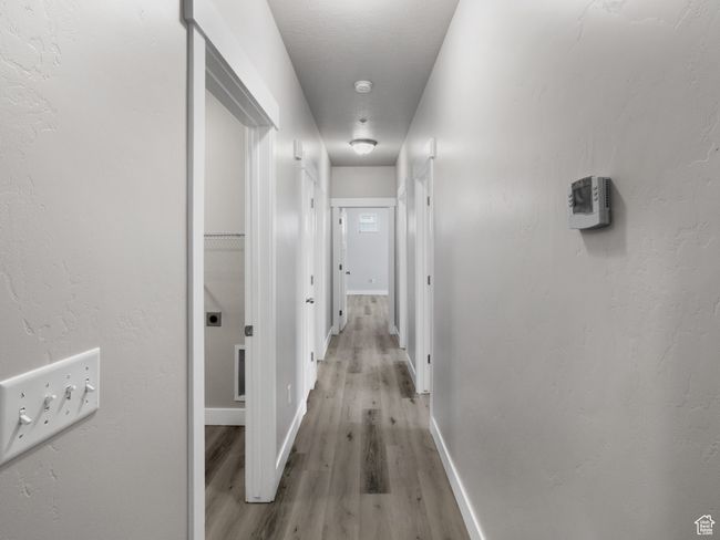 Hallway featuring light wood-type flooring and baseboards | Image 6