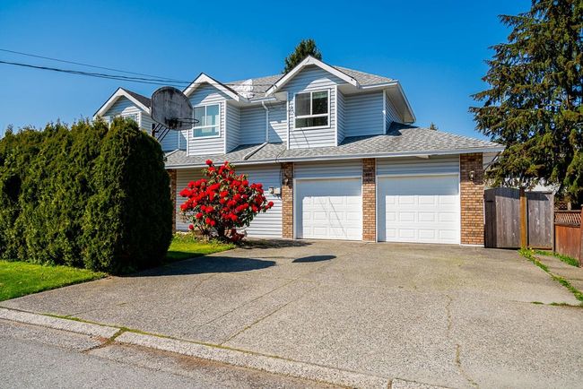 Traditional-style house featuring driveway, a shingled roof, fence, a garage, and brick siding | Image 36